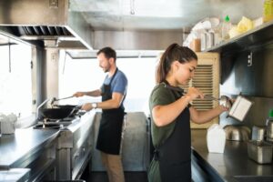Two people cooking in a food truck